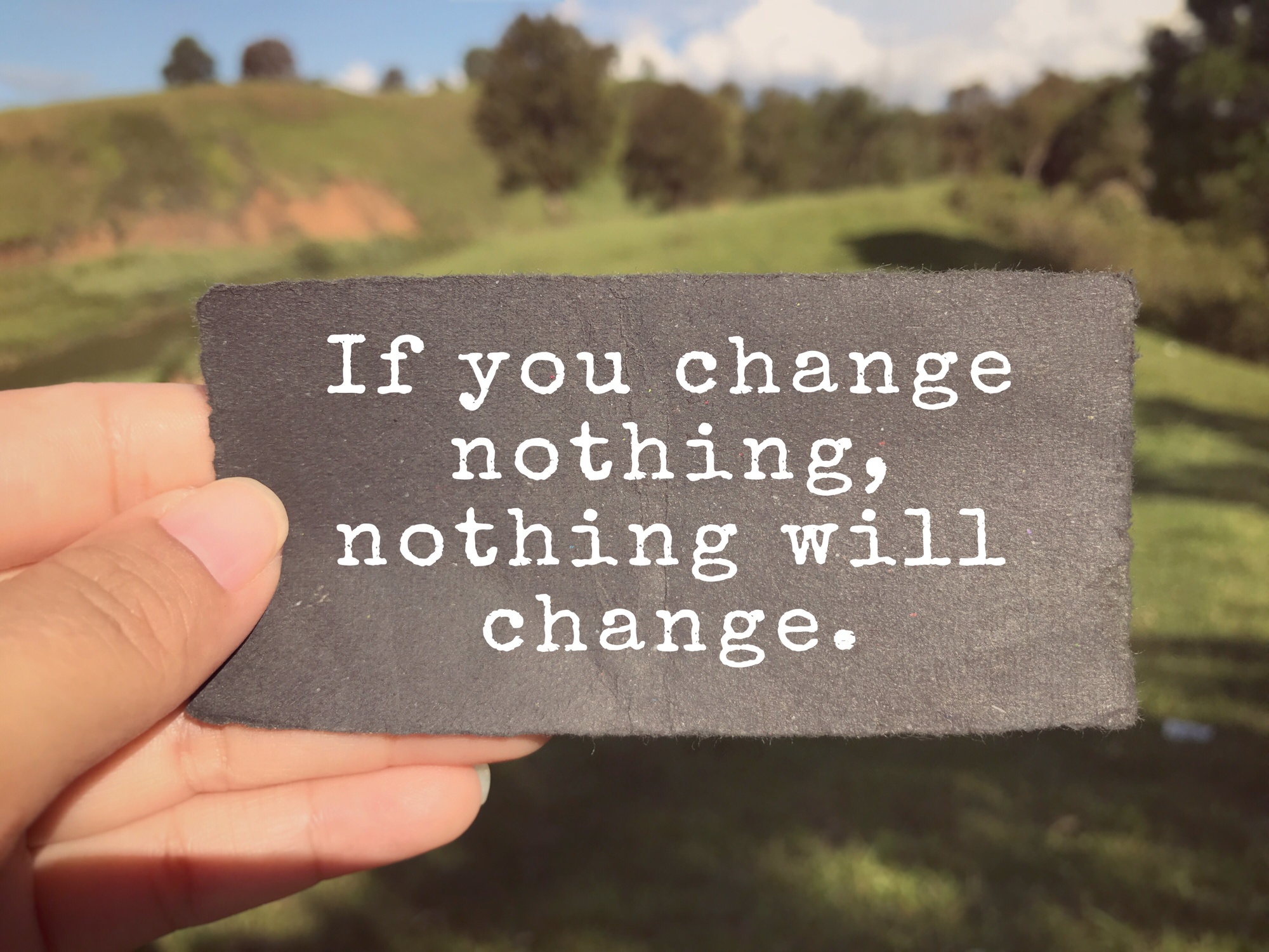 If You Change Nothing, Nothing Will Change written on a paper. Blurred vintage styled background.